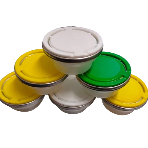 White, yellow and green plastic spout caps arranged as a product group